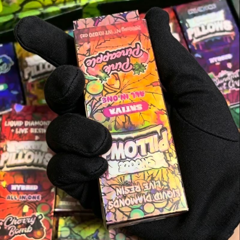 Gloved hand holding a single Pink Pineapple Snooze Pillows empty vape cart box.